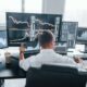 A day trader sits in front of a bunch of computer screens